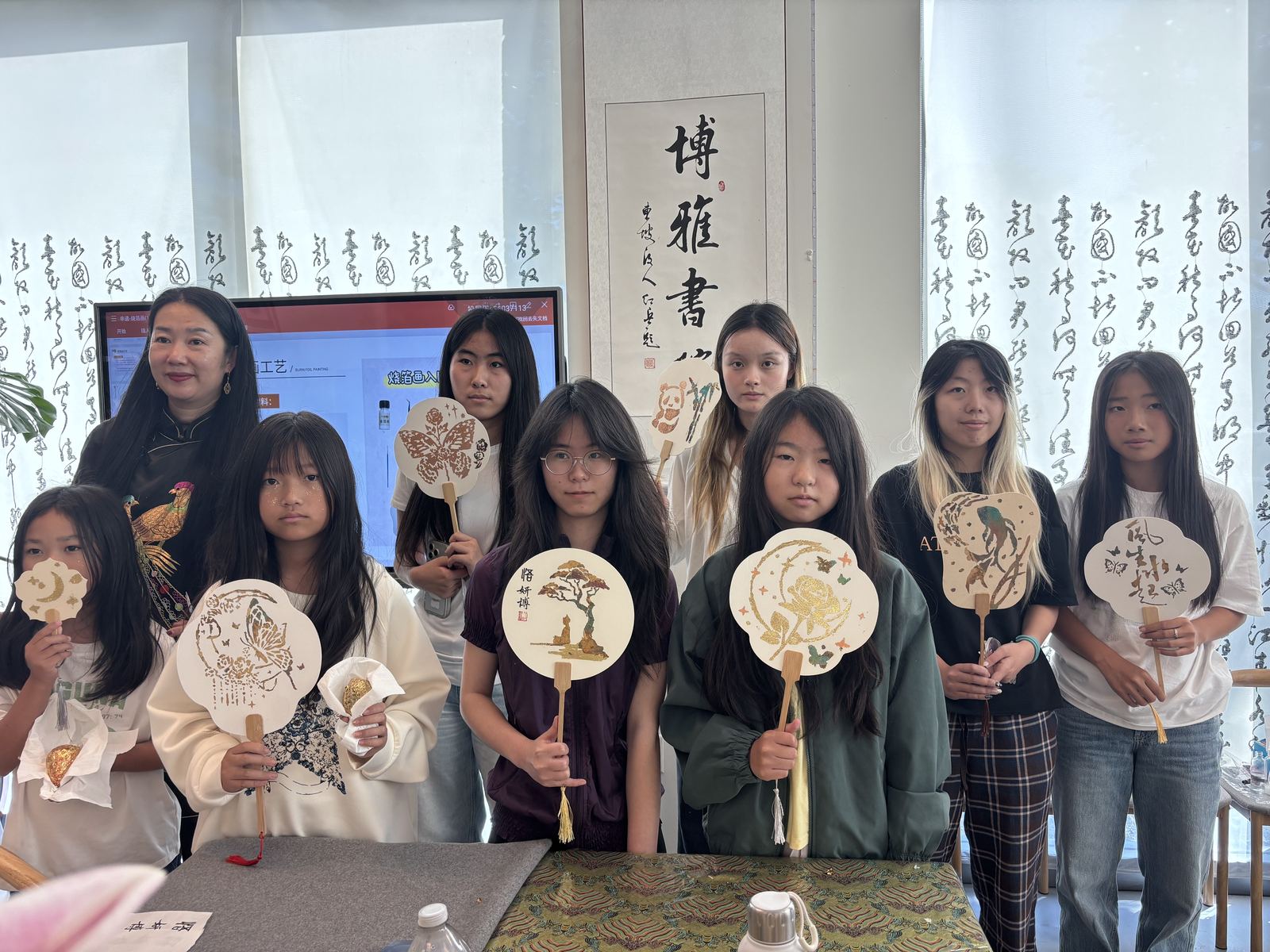 学员手持完成的非遗环保手工作品合影