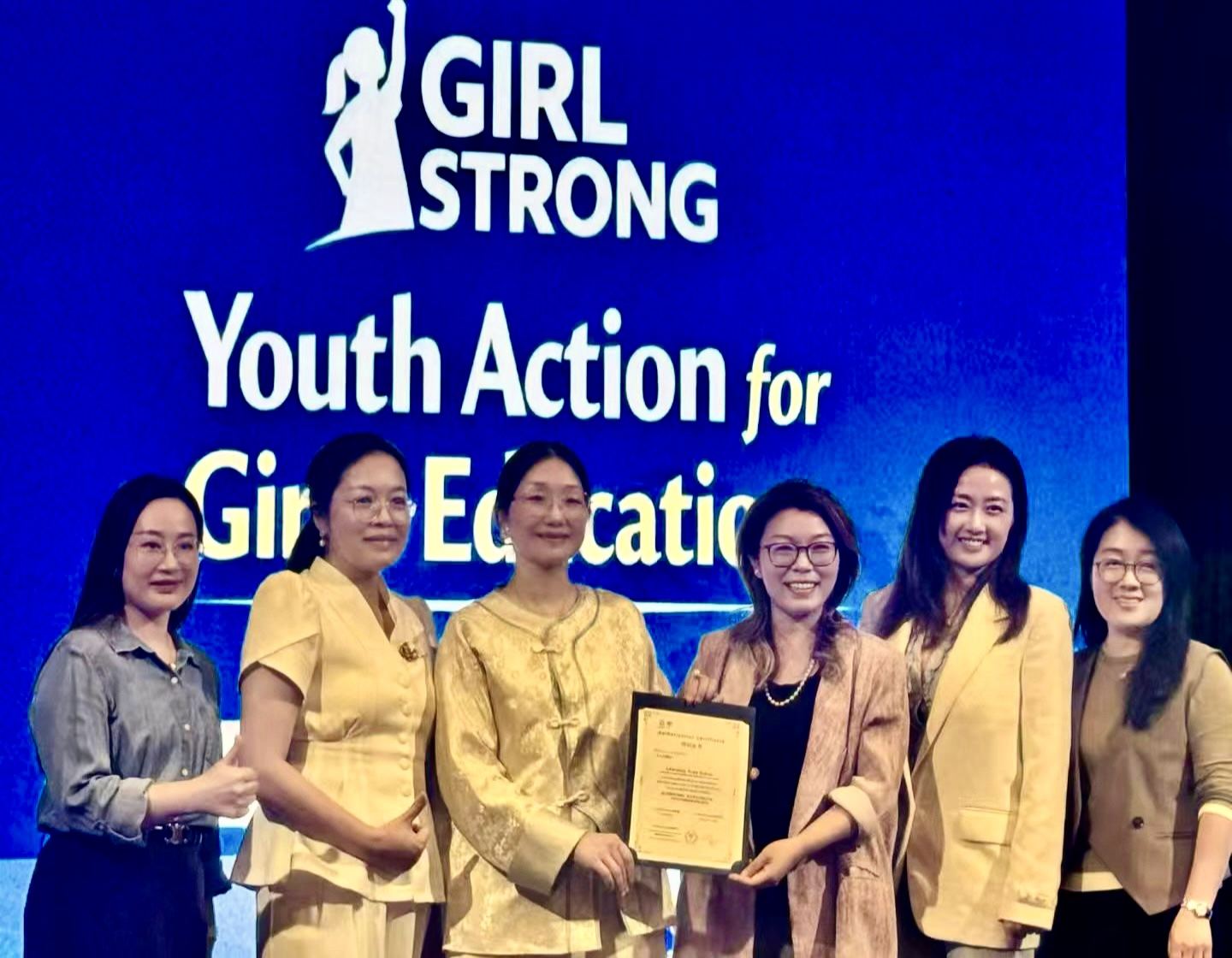 Girl Strong 全球女性支持行动现场,参与者手持奖牌合影