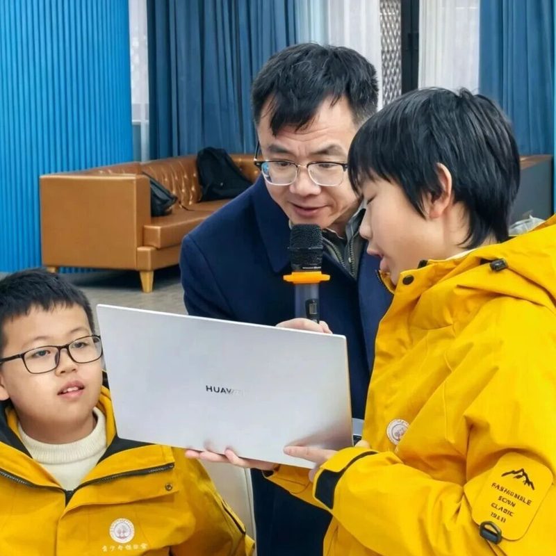 导师与两名学员一起看着笔记本电脑上的作品