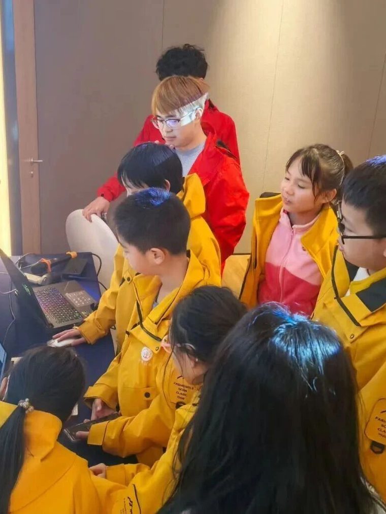 一群学员围在笔记本电脑前讨论