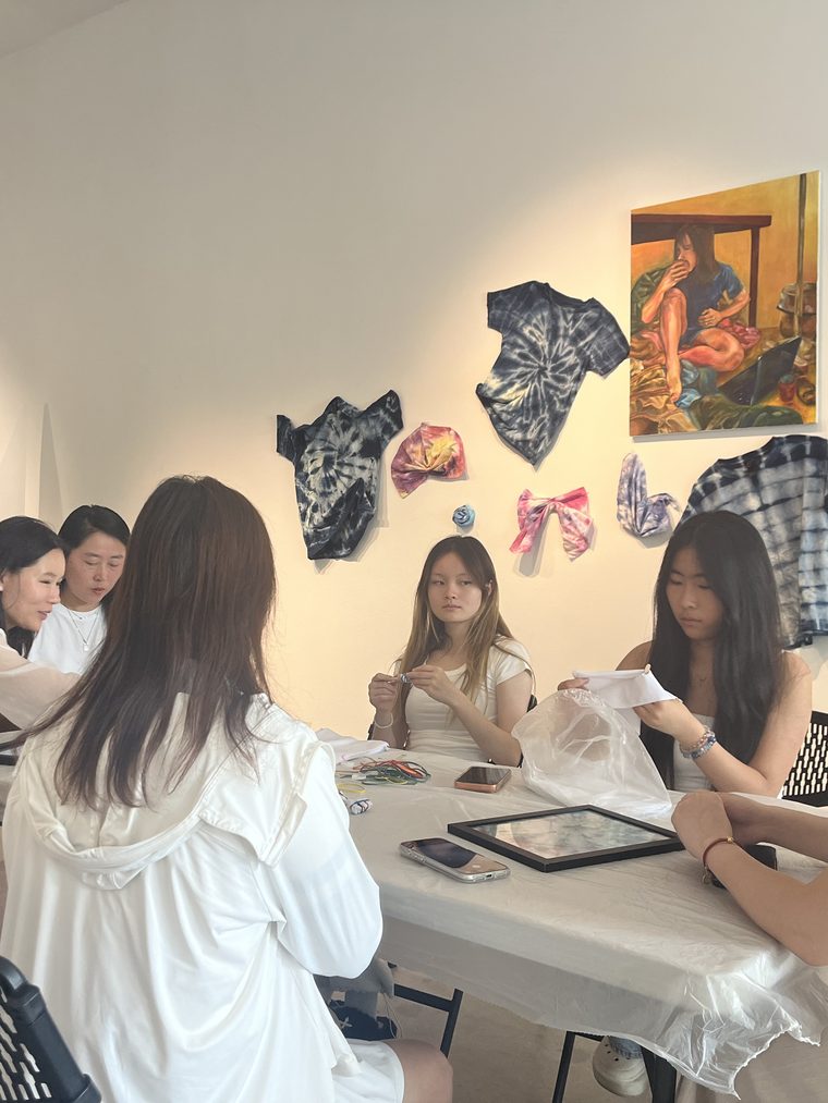 学员在展墙前的工作坊桌旁创作