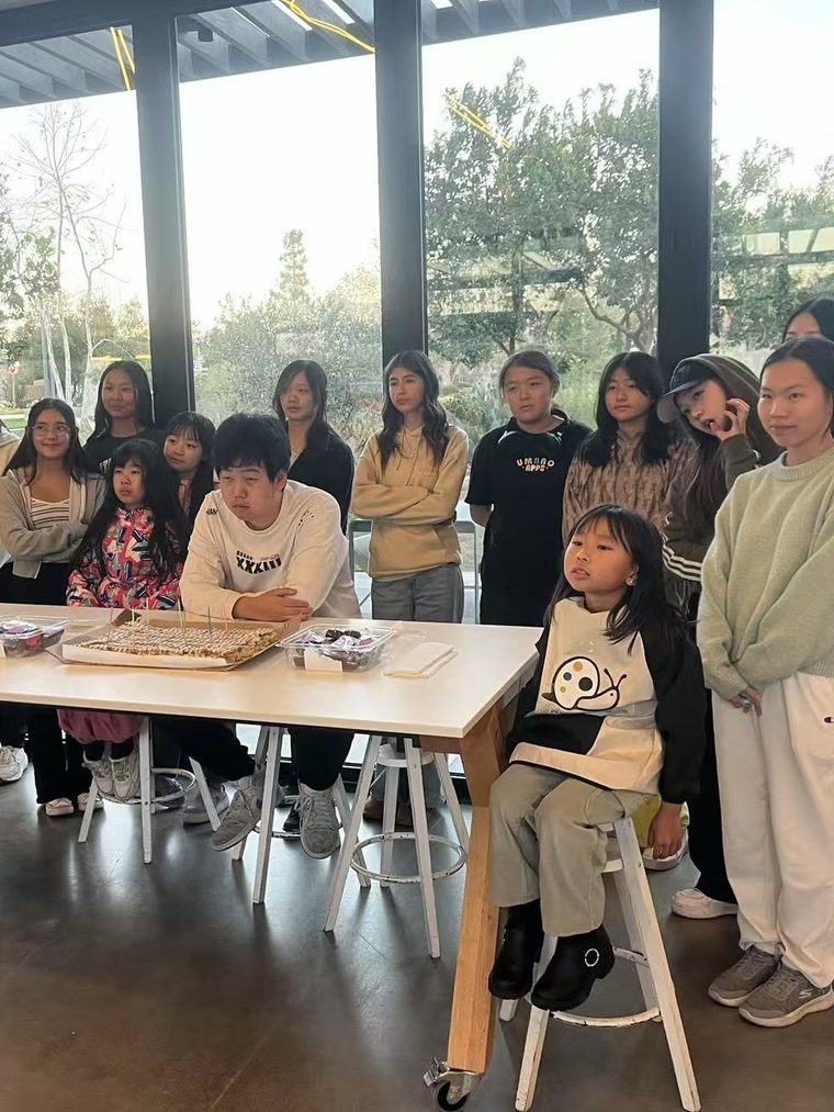 社区活动中围坐一桌的青少年与孩子们