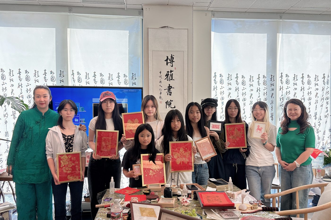 学员在书院工作室中手持自己完成的装裱作品合影
