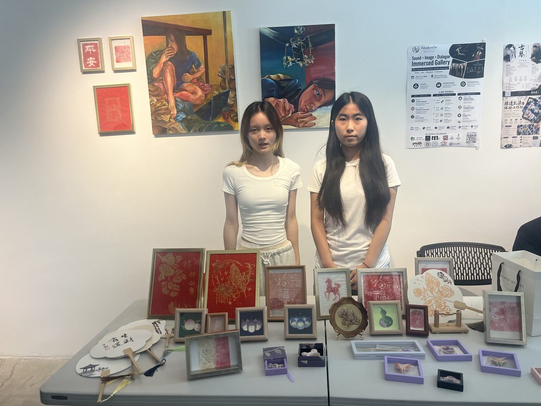 两位学员站在自己策展的作品桌前